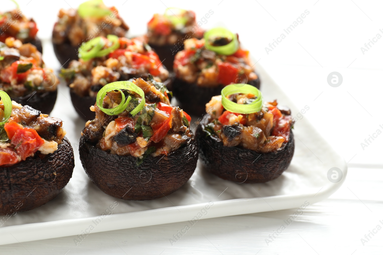 Delicious stuffed mushrooms on white table, closeup Photo of Delicious stuffed mushrooms on white table, closeup
