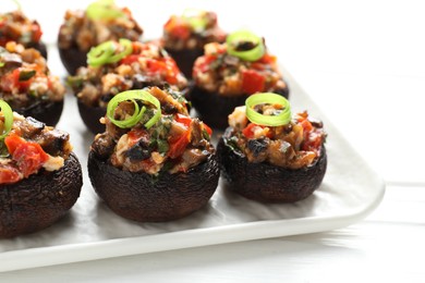 Photo of Delicious stuffed mushrooms on white table, closeup