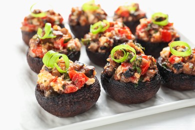 Photo of Delicious stuffed mushrooms on white table, closeup