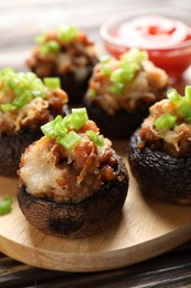 Photo of Delicious stuffed mushrooms and sauce on table, closeup