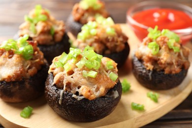 Photo of Delicious stuffed mushrooms and sauce on table, closeup