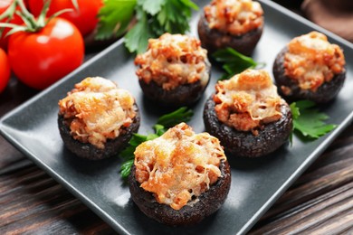 Photo of Delicious stuffed mushrooms with parsley on wooden table, closeup