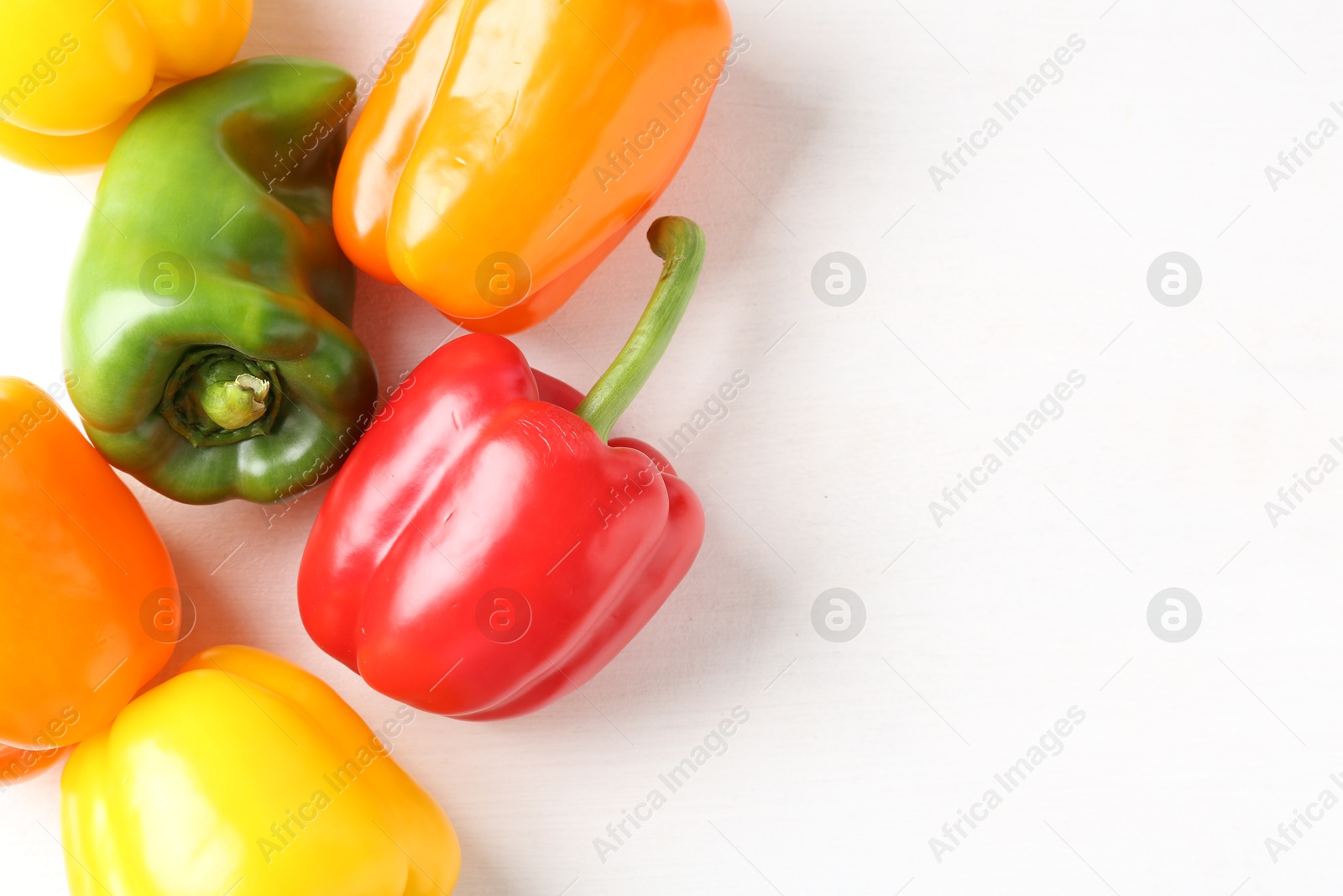 Ripe colorful bell peppers on white table, flat lay. Space for text Photo of Ripe colorful bell peppers on white table, flat lay. Space for text