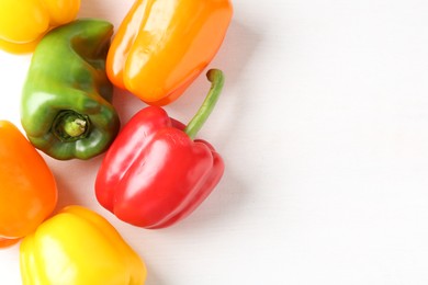 Photo of Ripe colorful bell peppers on white table, flat lay. Space for text