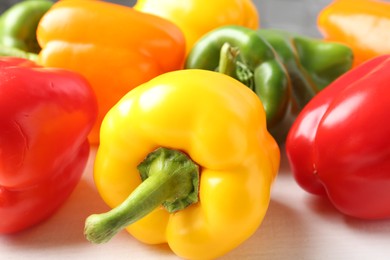Photo of Ripe colorful bell peppers on white table, closeup