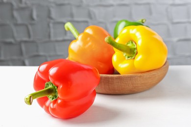 Photo of Ripe colorful bell peppers on white table