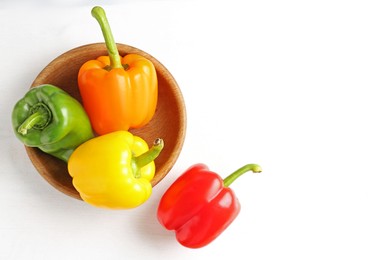 Photo of Ripe colorful bell peppers on white table, flat lay. Space for text