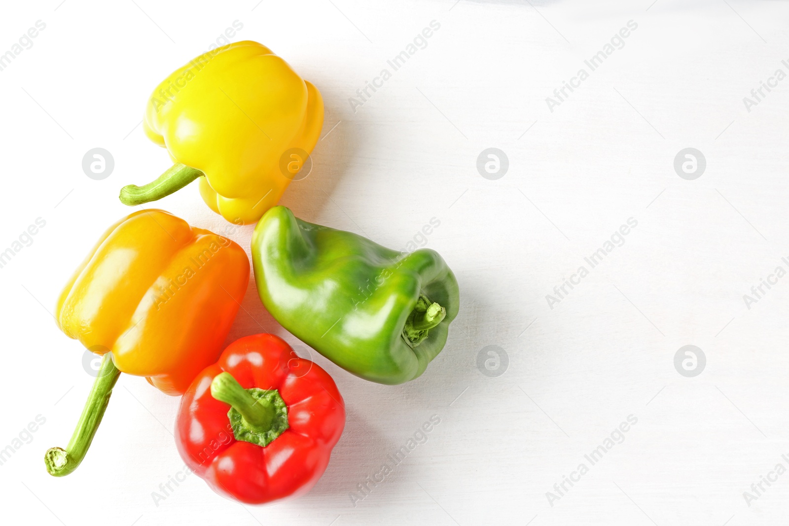 Ripe colorful bell peppers on white table, flat lay. Space for text Photo of Ripe colorful bell peppers on white table, flat lay. Space for text