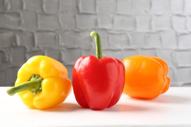 Photo of Ripe colorful bell peppers on white table