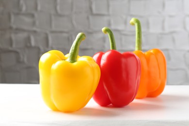 Photo of Ripe colorful bell peppers on white table