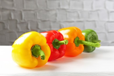 Photo of Ripe colorful bell peppers on white table