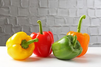 Photo of Ripe colorful bell peppers on white table