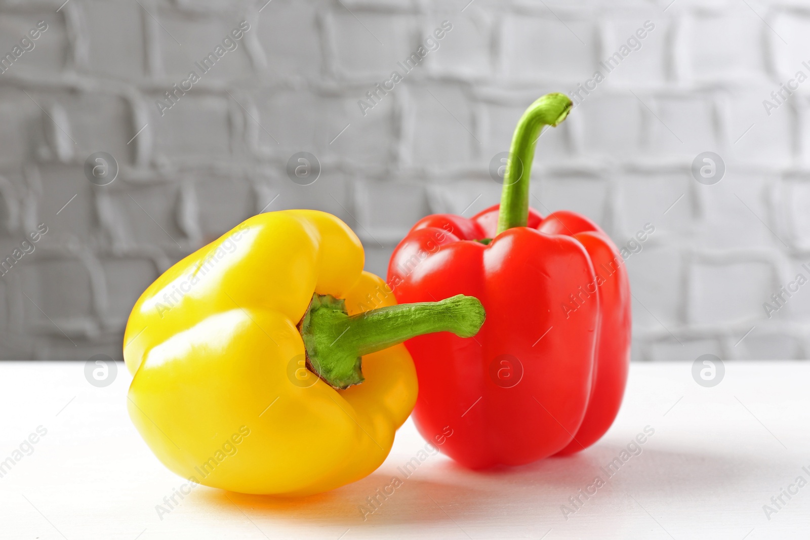 Ripe colorful bell peppers on white table Photo of Ripe colorful bell peppers on white table