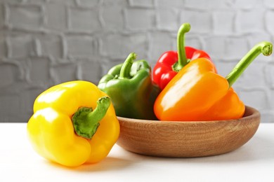 Photo of Ripe colorful bell peppers on white table