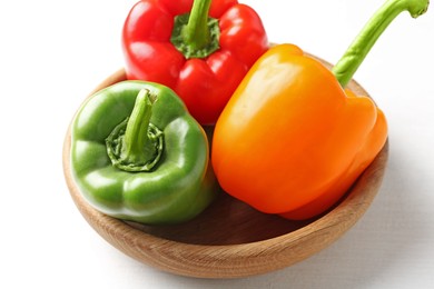 Photo of Ripe colorful bell peppers on white table, closeup