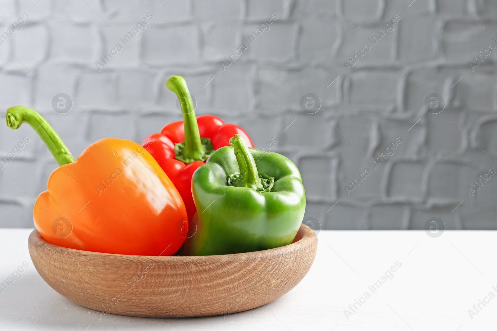 Ripe colorful bell peppers on white table. Space for text Photo of Ripe colorful bell peppers on white table. Space for text