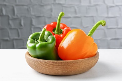 Photo of Ripe colorful bell peppers on white table
