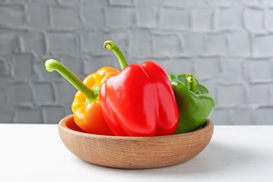 Photo of Ripe colorful bell peppers on white table