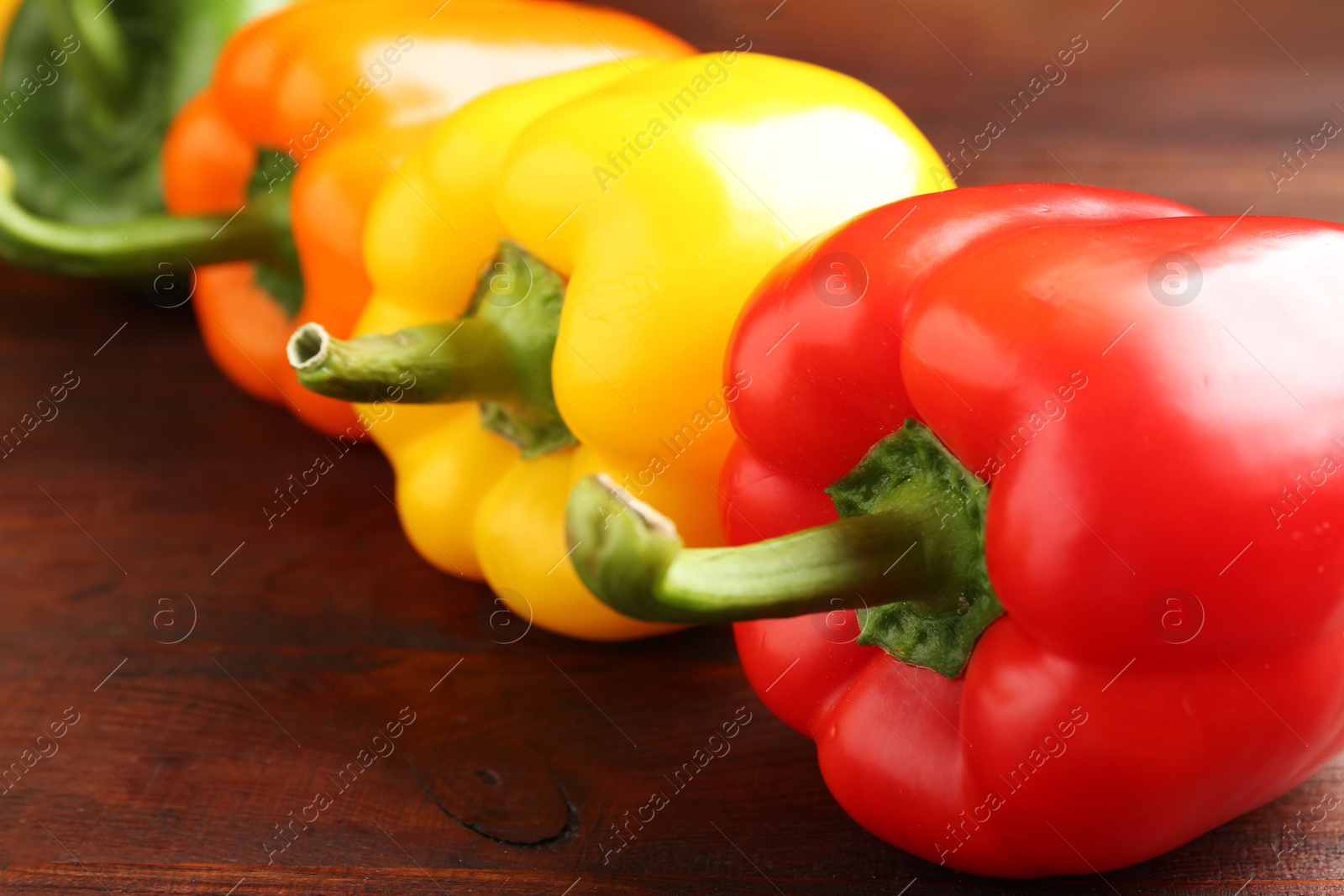 Ripe colorful bell peppers on wooden table, closeup Photo of Ripe colorful bell peppers on wooden table, closeup