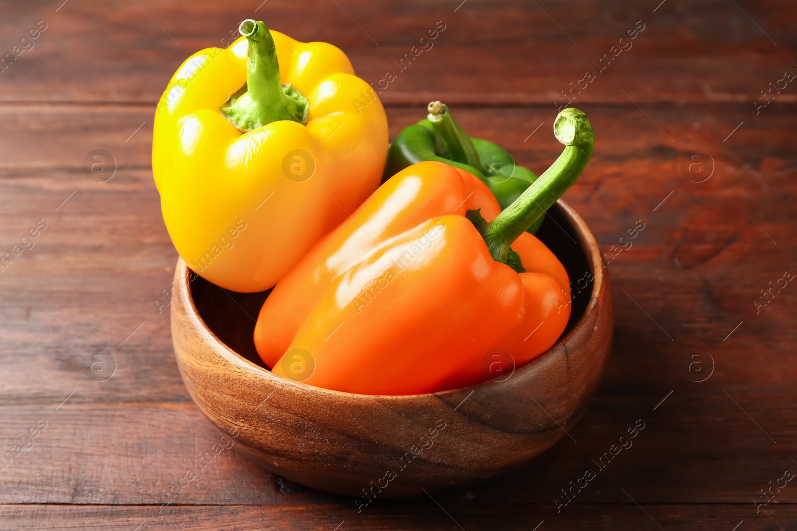 Ripe colorful bell peppers on wooden table, closeup Photo of Ripe colorful bell peppers on wooden table, closeup