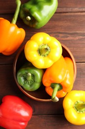 Photo of Ripe colorful bell peppers on wooden table, flat lay