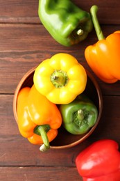 Photo of Ripe colorful bell peppers on wooden table, flat lay