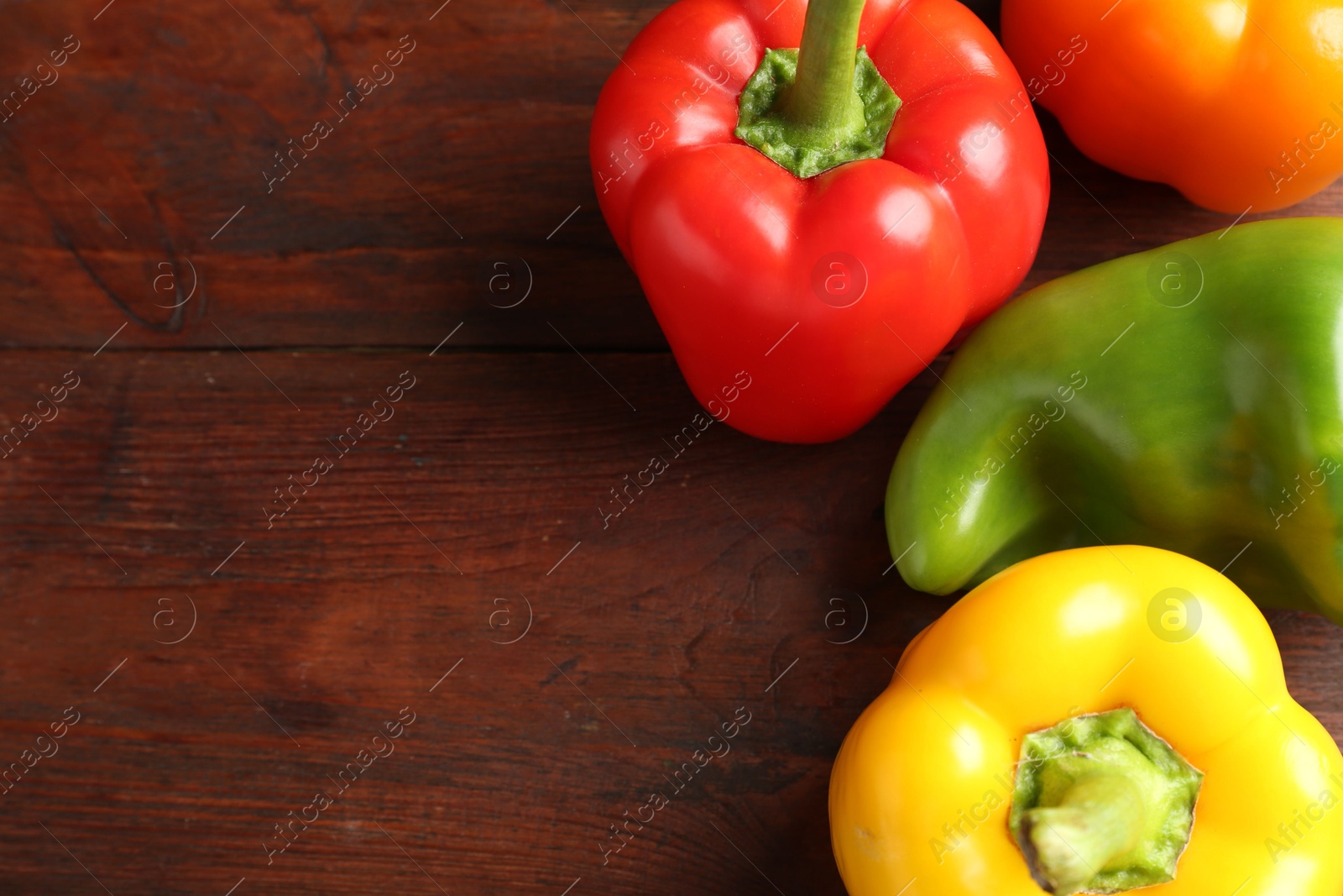 Ripe colorful bell peppers on wooden table, closeup. Space for text Photo of Ripe colorful bell peppers on wooden table, closeup. Space for text