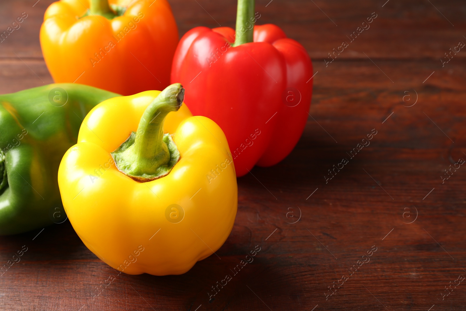 Ripe colorful bell peppers on wooden table, closeup Photo of Ripe colorful bell peppers on wooden table, closeup