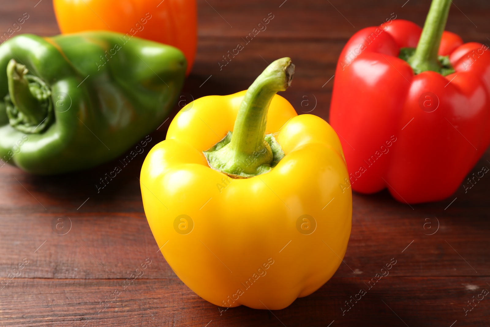 Ripe colorful bell peppers on wooden table, closeup Photo of Ripe colorful bell peppers on wooden table, closeup