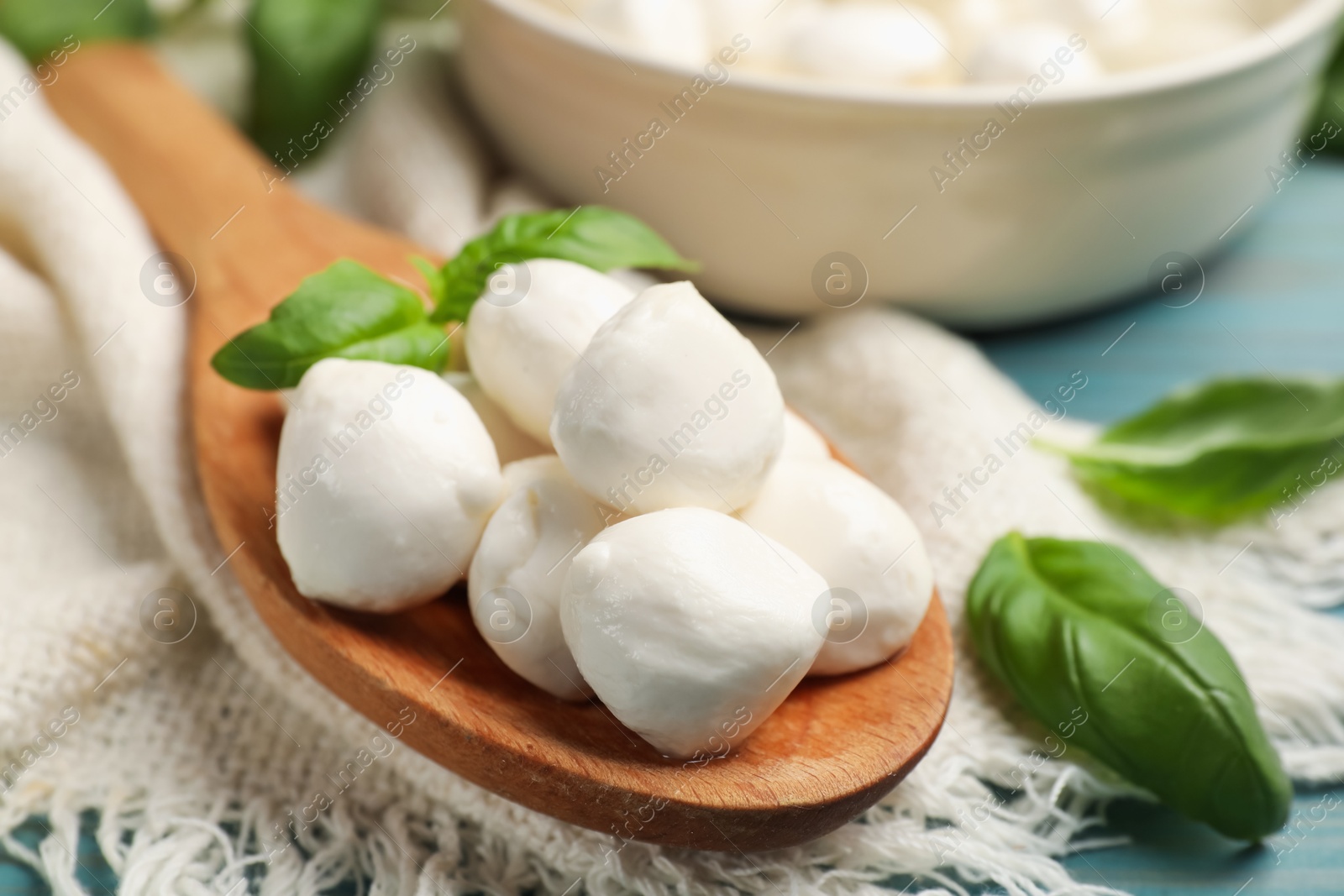 Mozzarella cheese balls and basil on blue wooden table, closeup Photo of Mozzarella cheese balls and basil on blue wooden table, closeup