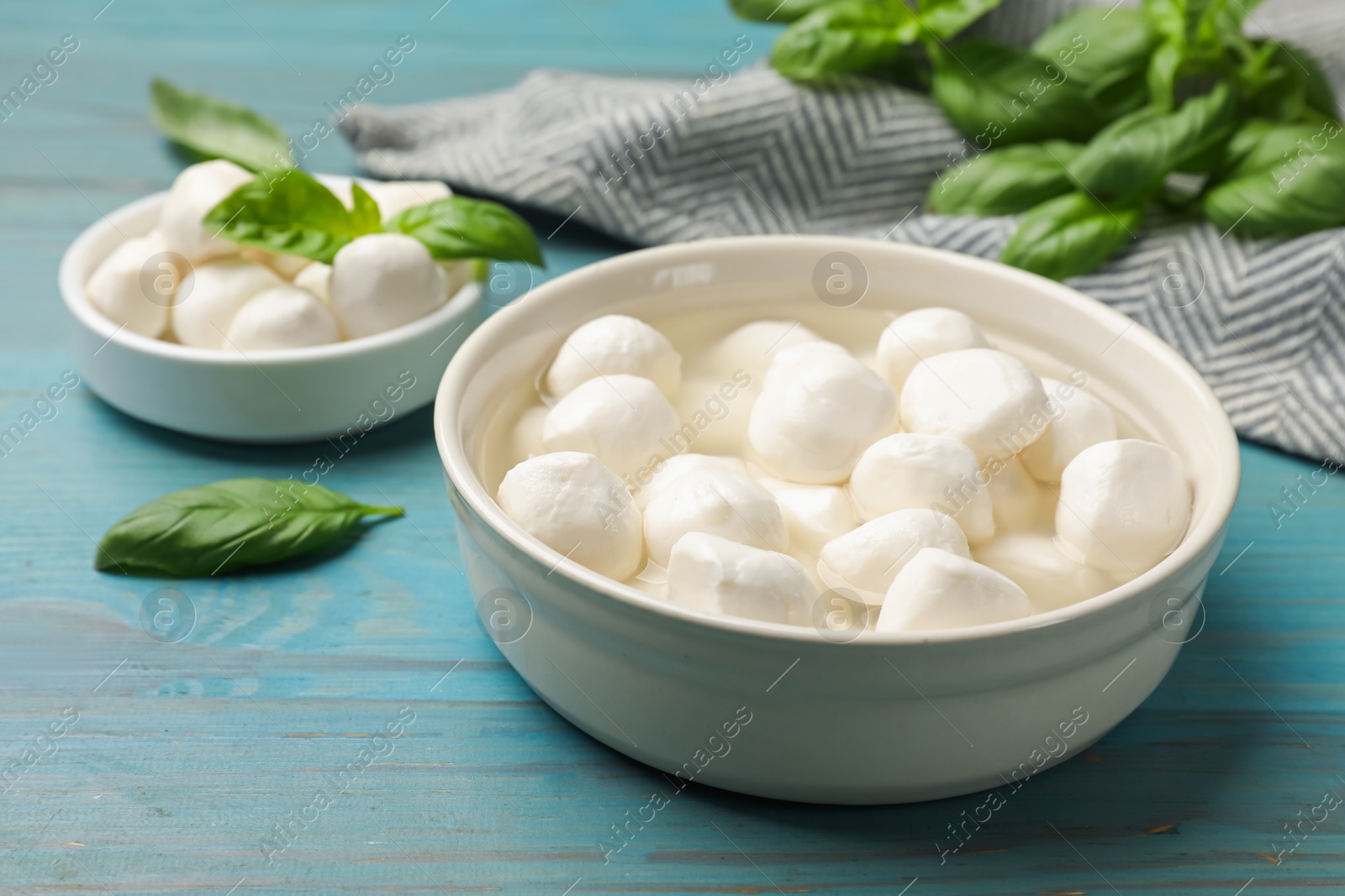 Mozzarella cheese balls and basil on blue wooden table, closeup Photo of Mozzarella cheese balls and basil on blue wooden table, closeup