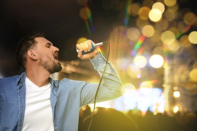 Image of Young handsome man singing at open air festival