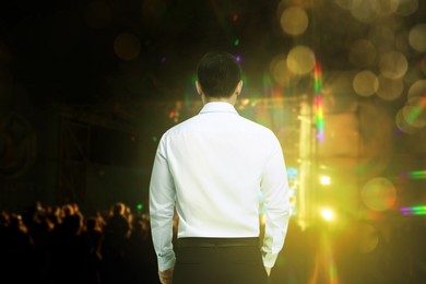 Image of Man performing at open air festival, back view