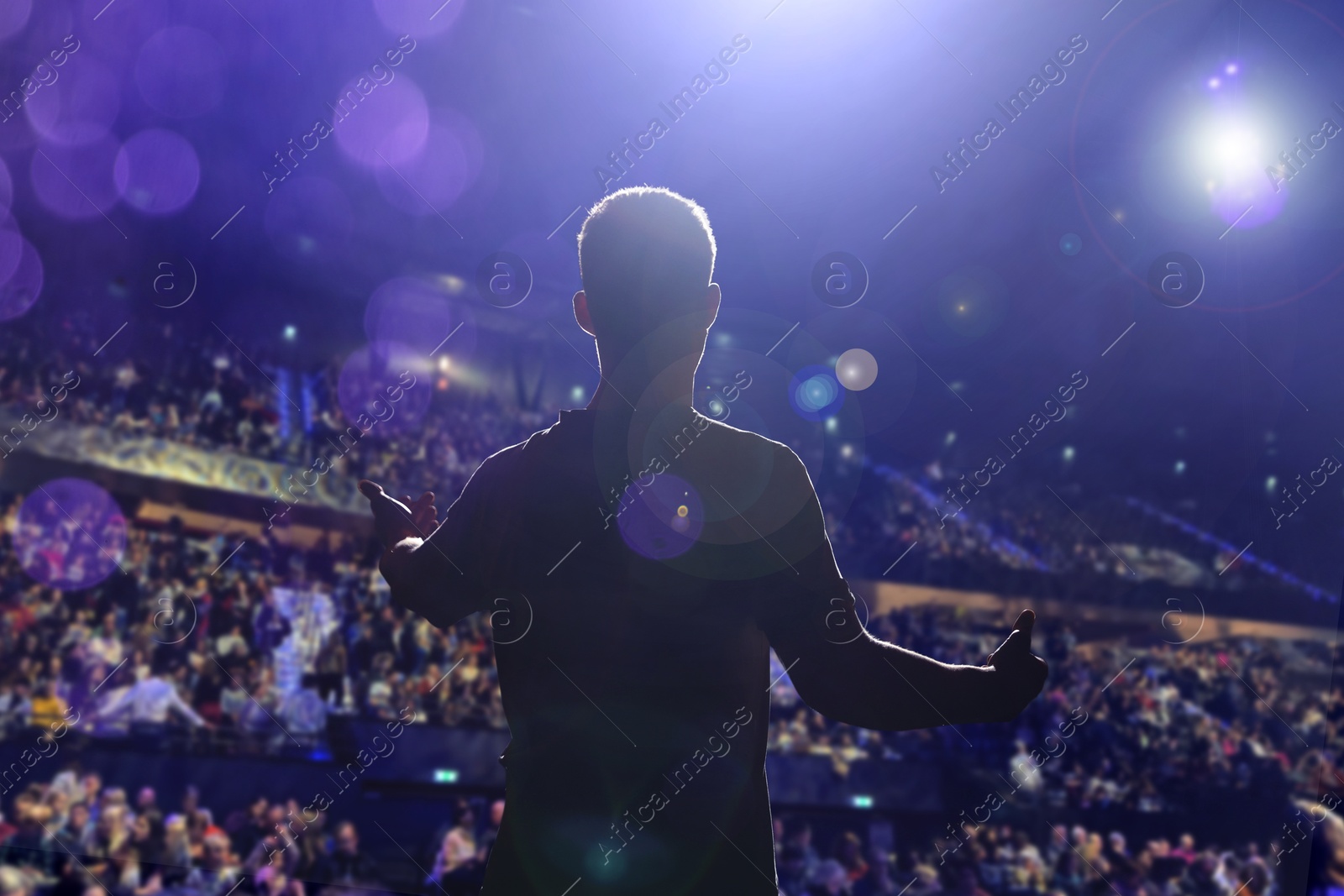 Man performing on stage of concert hall crowded with people Image of Man performing on stage of concert hall crowded with people