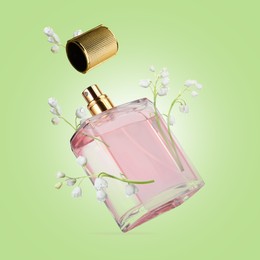 Image of Lilies of the valley and bottle of perfume in air on light green background