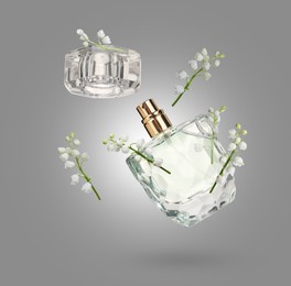 Image of Lilies of the valley and bottle of perfume in air on grey background