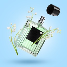 Image of Lilies of the valley and bottle of perfume in air on light blue background
