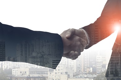 Image of Businessmen shaking hands, double exposure with cityscape. Successful partnership and startup