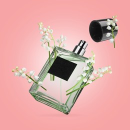 Image of Lilies of the valley and bottle of perfume in air on pink background