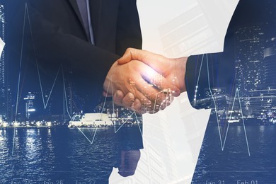 Image of Businessmen shaking hands, double exposure with cityscape. Successful partnership and startup