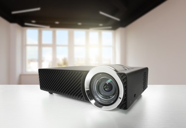 Image of Modern video projector on white table in room
