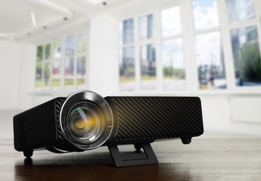 Image of Modern video projector on wooden table in room