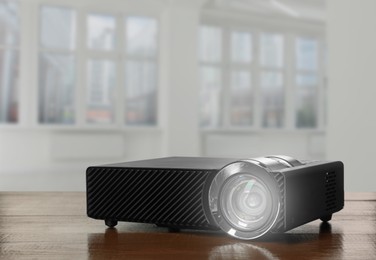 Image of Modern video projector on wooden table in room