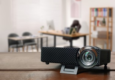 Image of Modern video projector on wooden table in office