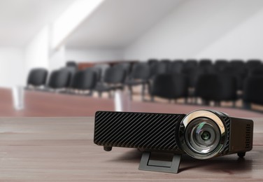 Image of Modern video projector on wooden table in conference room