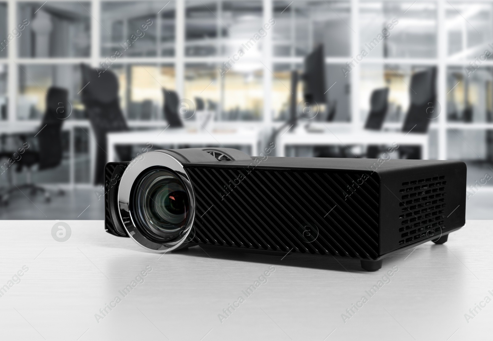 Modern video projector on white table in office Image of Modern video projector on white table in office