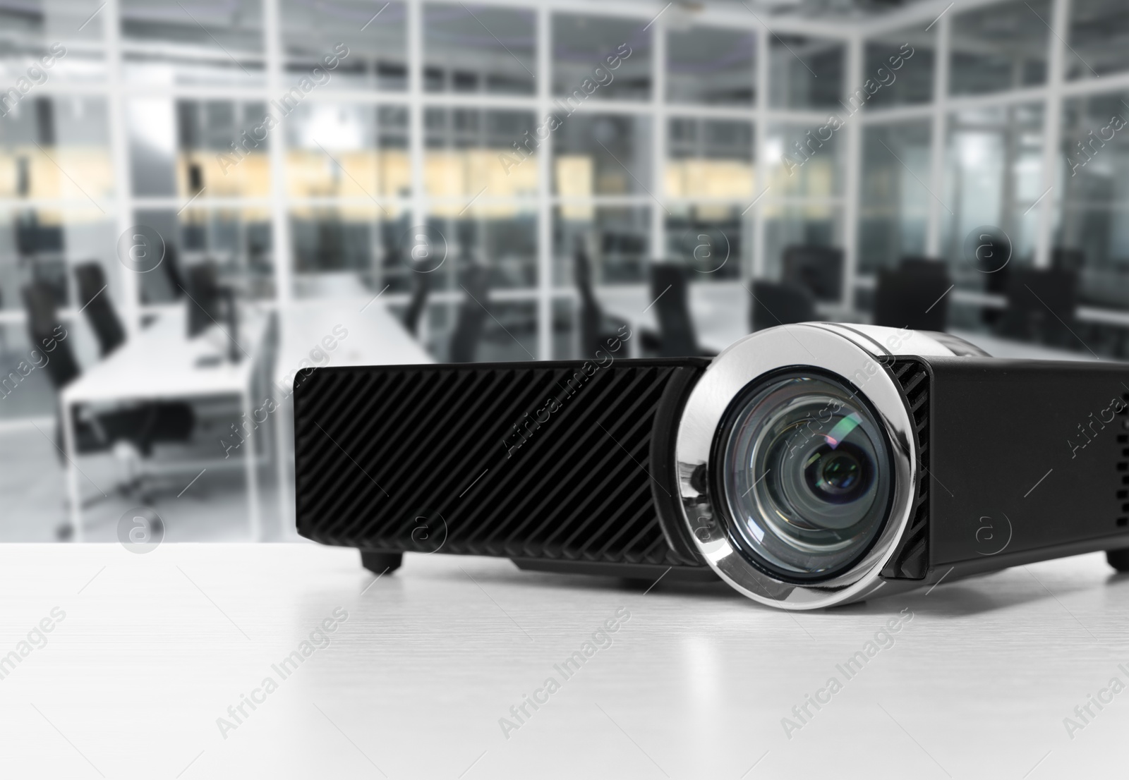 Modern video projector on white table in office Image of Modern video projector on white table in office