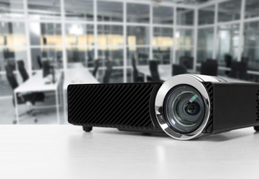Image of Modern video projector on white table in office