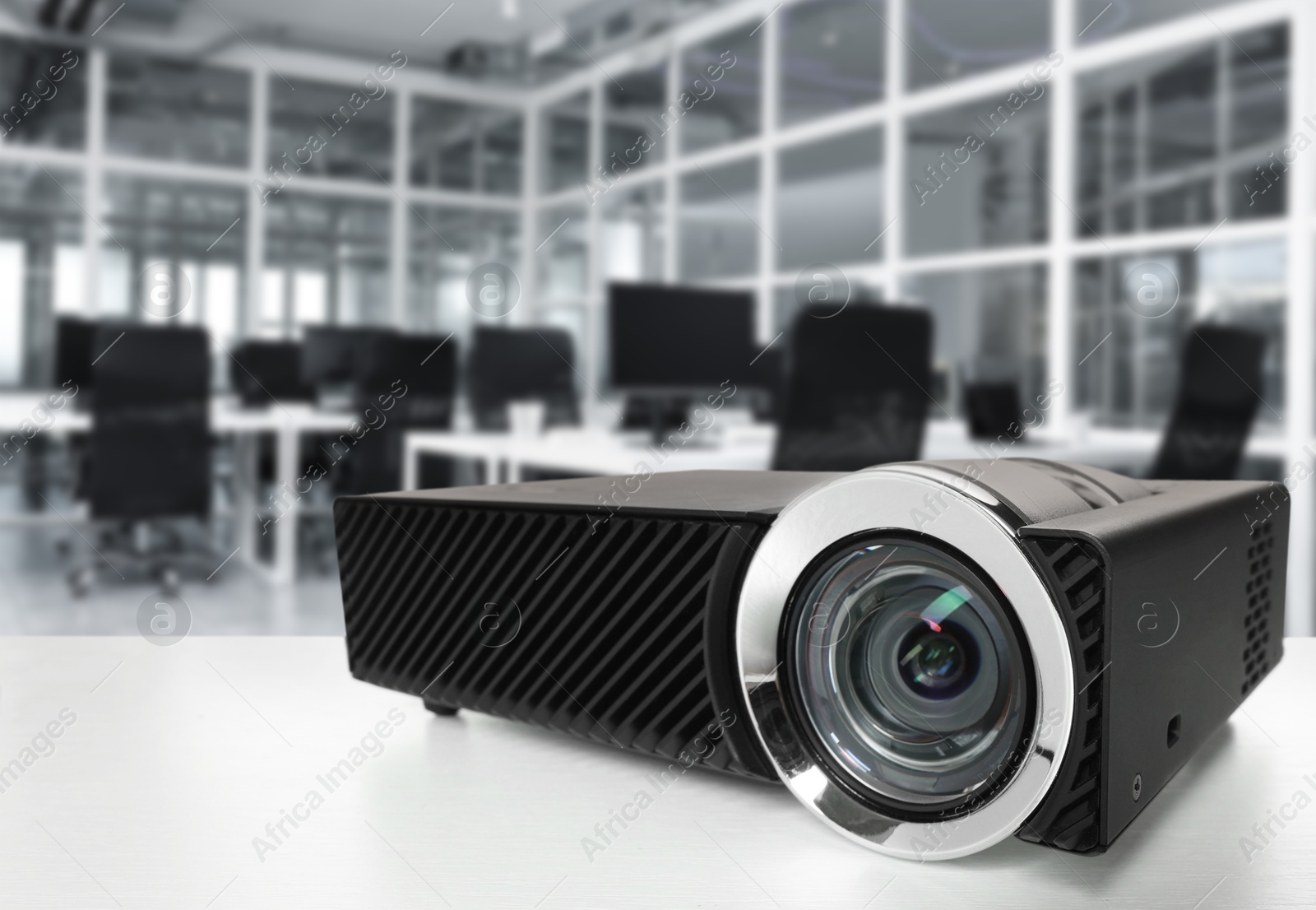 Modern video projector on white table in office Image of Modern video projector on white table in office