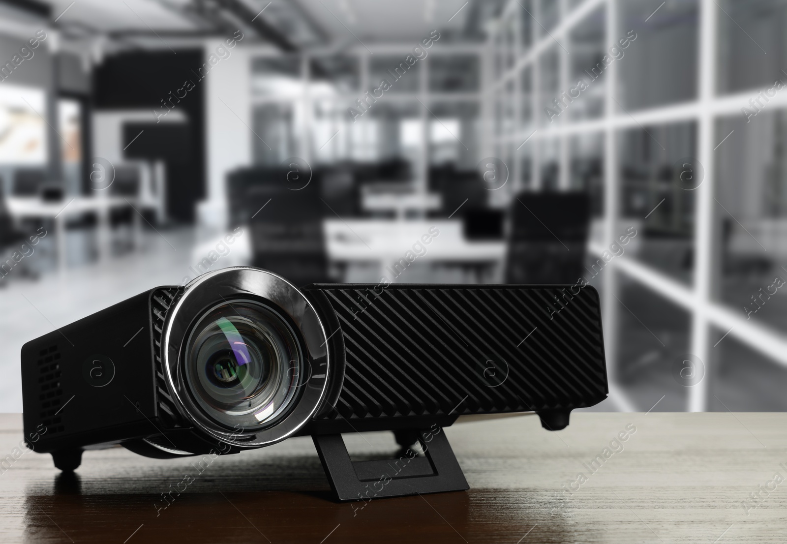Modern video projector on wooden table in office Image of Modern video projector on wooden table in office